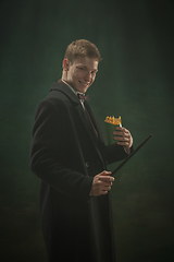 Image showing Young man in art action isolated on dark green background. Retro style, comparison of eras concept.