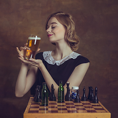 Image showing Young woman in art action isolated on brown background. Retro style, comparison of eras concept.