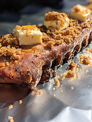 Image showing Close-up view of delicious juicy meat with ribs on grill