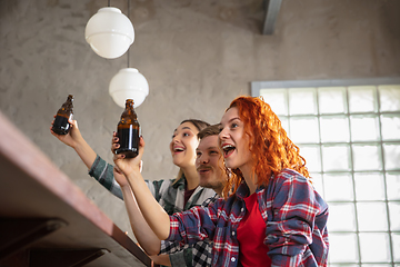 Image showing Group of friends watching sport match together. Emotional fans cheering for favourite team, watching on exciting game. Concept of friendship, leisure activity, emotions