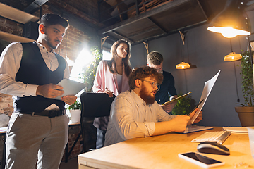 Image showing Colleagues working together in modern office using devices and gadgets during creative meeting