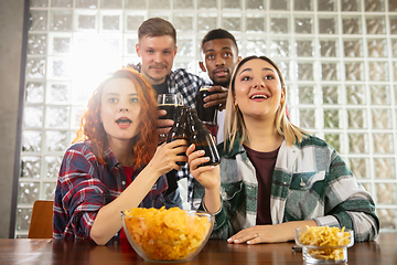 Image showing Group of friends watching sport match together. Emotional fans cheering for favourite team, watching on exciting game. Concept of friendship, leisure activity, emotions