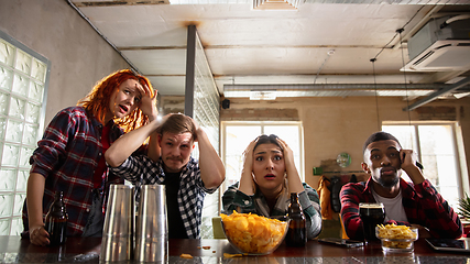 Image showing Group of friends watching sport match together. Emotional fans cheering for favourite team, watching on exciting game. Concept of friendship, leisure activity, emotions