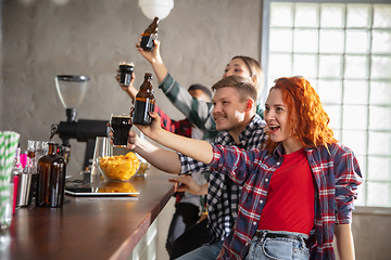 Image showing Group of friends watching sport match together. Emotional fans cheering for favourite team, watching on exciting game. Concept of friendship, leisure activity, emotions