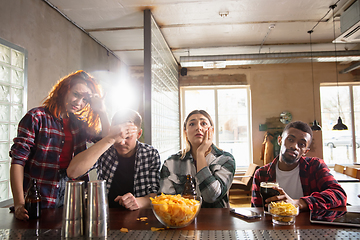 Image showing Group of friends watching sport match together. Emotional fans cheering for favourite team, watching on exciting game. Concept of friendship, leisure activity, emotions