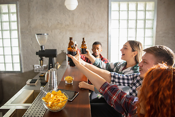 Image showing Group of friends watching sport match together. Emotional fans cheering for favourite team, watching on exciting game. Concept of friendship, leisure activity, emotions