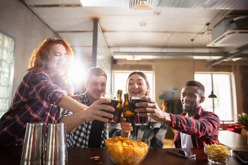 Image showing Group of friends watching sport match together. Emotional fans cheering for favourite team, watching on exciting game. Concept of friendship, leisure activity, emotions