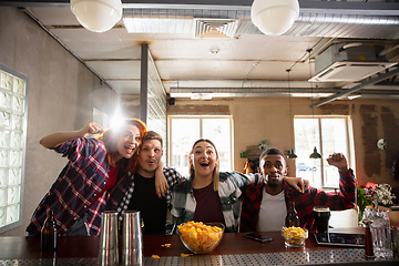 Image showing Group of friends watching sport match together. Emotional fans cheering for favourite team, watching on exciting game. Concept of friendship, leisure activity, emotions