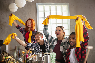 Image showing Group of friends watching sport match together. Emotional fans cheering for favourite team, watching on exciting game. Concept of friendship, leisure activity, emotions