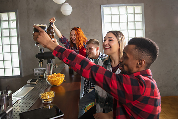 Image showing Group of friends watching sport match together. Emotional fans cheering for favourite team, watching on exciting game. Concept of friendship, leisure activity, emotions