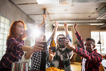 Image showing Group of friends watching sport match together. Emotional fans cheering for favourite team, watching on exciting game. Concept of friendship, leisure activity, emotions