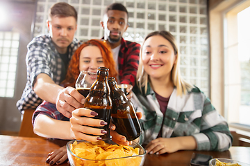 Image showing Group of friends watching sport match together. Emotional fans cheering for favourite team, watching on exciting game. Concept of friendship, leisure activity, emotions