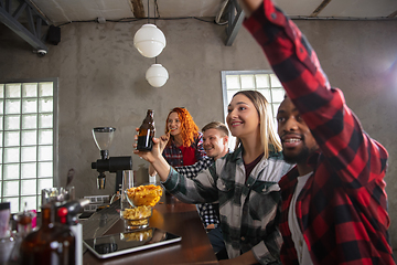 Image showing Group of friends watching sport match together. Emotional fans cheering for favourite team, watching on exciting game. Concept of friendship, leisure activity, emotions