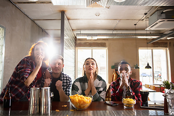 Image showing Group of friends watching sport match together. Emotional fans cheering for favourite team, watching on exciting game. Concept of friendship, leisure activity, emotions