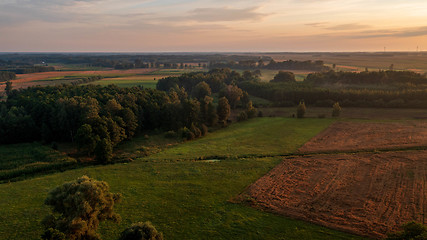 Image showing Colorful sunset over forest and fields aerial