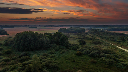 Image showing Colorful sunset over forest and fields aerial