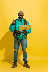 Image showing Full length portrait of a cheerful young african tourist guy isolated on yellow background