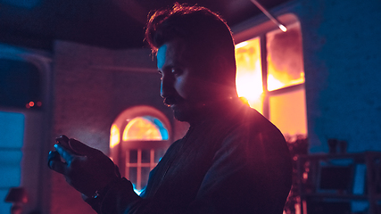 Image showing Cinematic portrait of handsome man in neon lighted interior