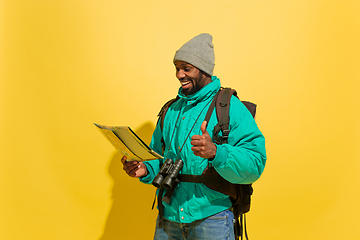 Image showing Full length portrait of a cheerful young african tourist guy isolated on yellow background