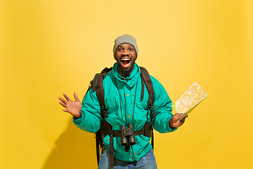 Image showing Full length portrait of a cheerful young african tourist guy isolated on yellow background