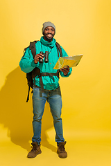 Image showing Full length portrait of a cheerful young african tourist guy isolated on yellow background