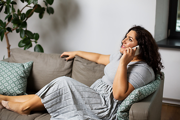 Image showing happy young woman calling on smartphone at home