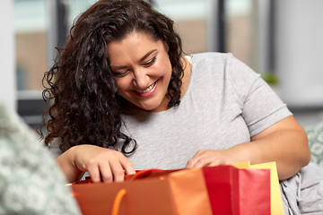 Image showing happy young woman with shopping bags at home