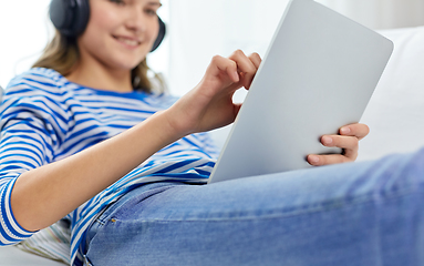 Image showing teenage girl listening to music on tablet computer