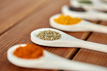 Image showing spoons with different spices on wooden table