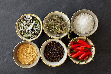 Image showing bowls with different spices on slate stone table