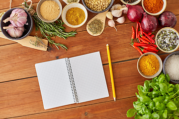 Image showing notebook with pencil among spices on wooden table