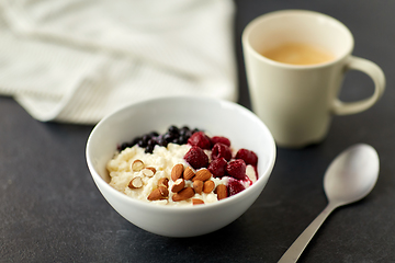 Image showing porridge breakfast with berries, almonds and spoon