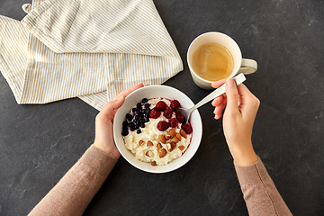 Image showing hands with porridge breakfast and cup of coffee