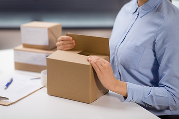 Image showing woman packing parcel box at post office