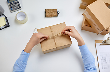 Image showing female hands packing parcel box at post office