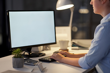 Image showing businesswoman working on computer at night office