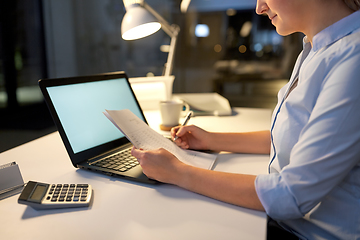 Image showing businesswoman with papers working at night office