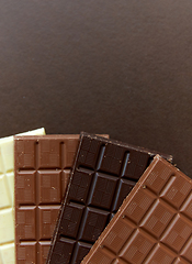 Image showing different kinds of chocolate on brown background