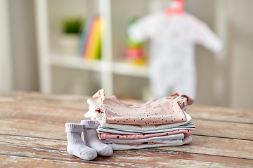 Image showing baby clothes on wooden table at home