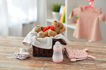 Image showing teddy bear toy in basket with baby things on table