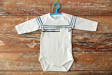 Image showing baby bodysuit with hanger on wooden table