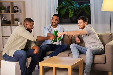 Image showing happy male friends drinking beer at home at night