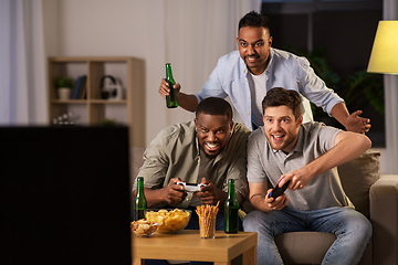 Image showing happy friends playing video games at home at night