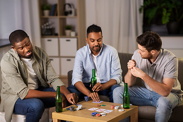 Image showing happy male friends playing cards at home at night