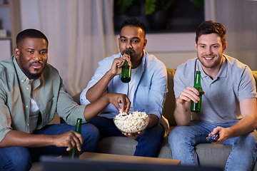 Image showing happy male friends with beer watching tv at home