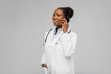 Image showing african female doctor calling on smartphone