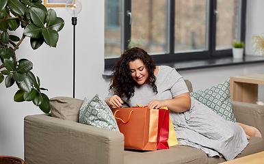 Image showing happy young woman with shopping bags at home