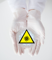 Image showing hands with coronavirus test and caution sign