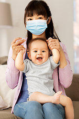 Image showing asian mother in protective mask with baby at home