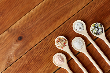 Image showing spoons with salt and spices on wooden table